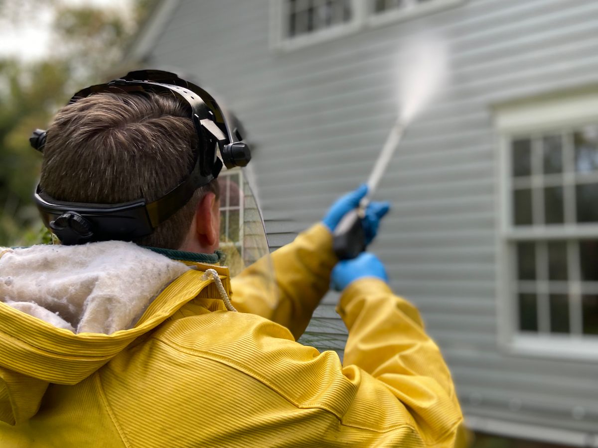 Clean residential driveway and exterior siding after pressure washing